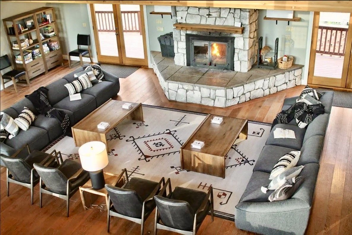 The great room seen from above: a stone fireplace, deep sofas and a patterned rug