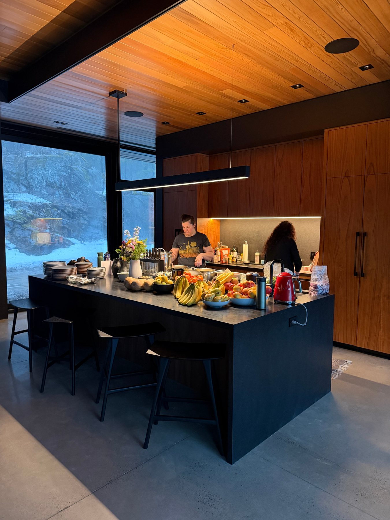 A kitchen island full of fresh fruit, with the chef at work