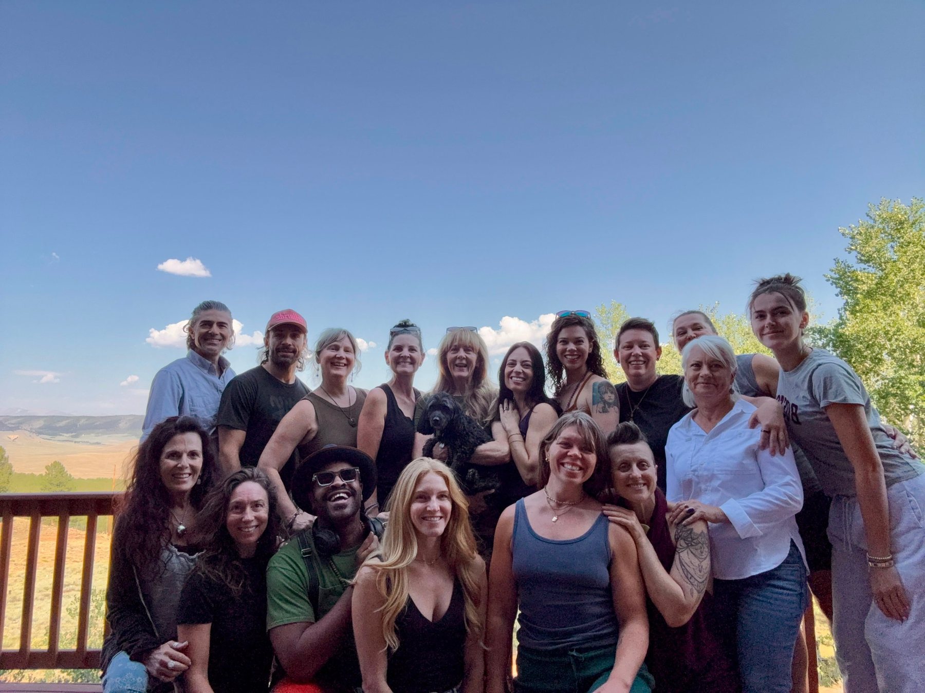The team gathered on a deck above a wide Colorado valley