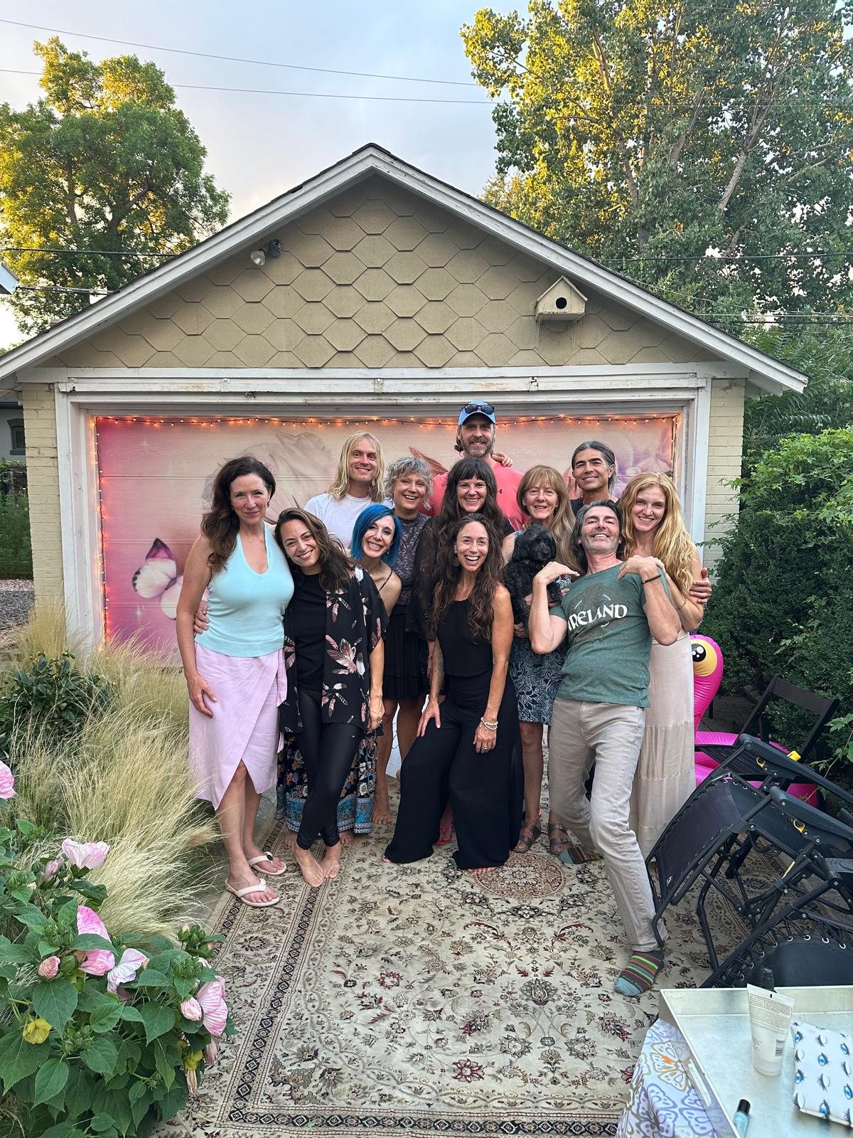The team smiling together in a garden strung with lights